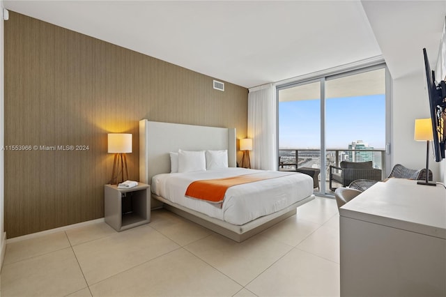 tiled bedroom featuring expansive windows and access to exterior