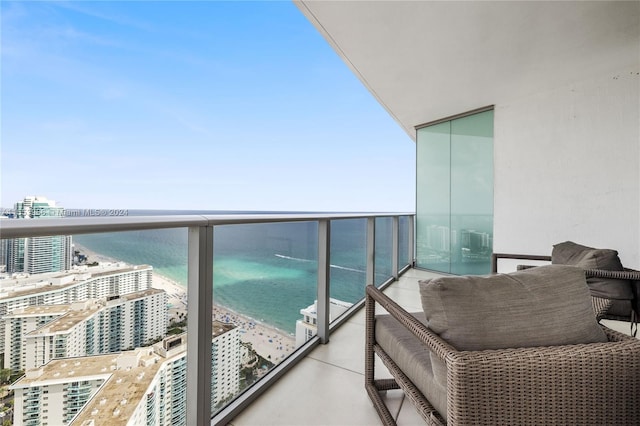 balcony featuring a water view and a view of the beach