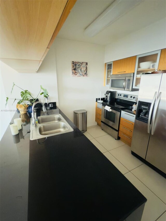 kitchen featuring appliances with stainless steel finishes, sink, and light tile patterned floors