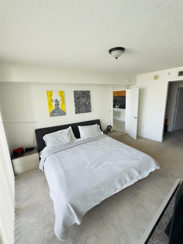 carpeted bedroom featuring a textured ceiling