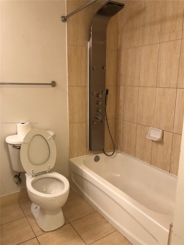 bathroom with tile patterned flooring, tiled shower / bath combo, and toilet