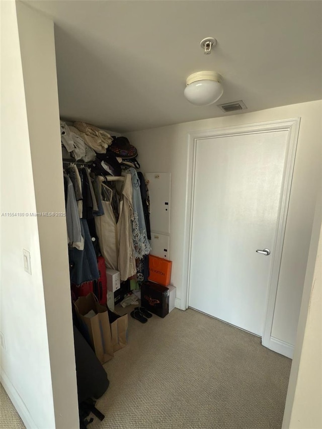 walk in closet featuring light colored carpet