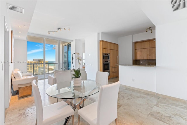 tiled dining space with a wall of windows