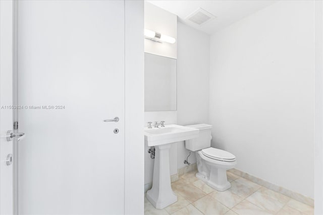 bathroom with toilet and tile flooring