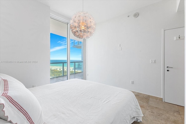 tiled bedroom featuring a water view, a notable chandelier, and access to outside