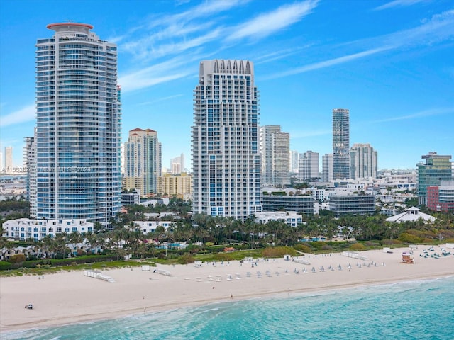 property's view of city featuring a water view and a beach view