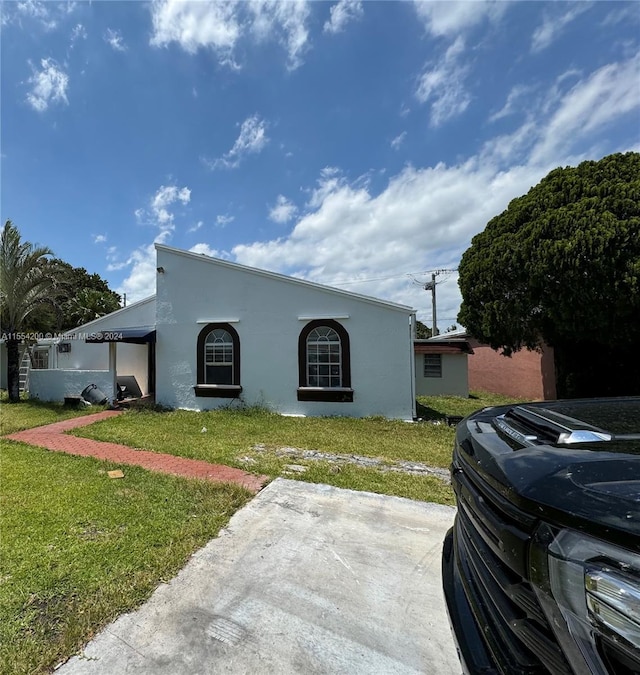 mediterranean / spanish-style home featuring a front lawn and stucco siding