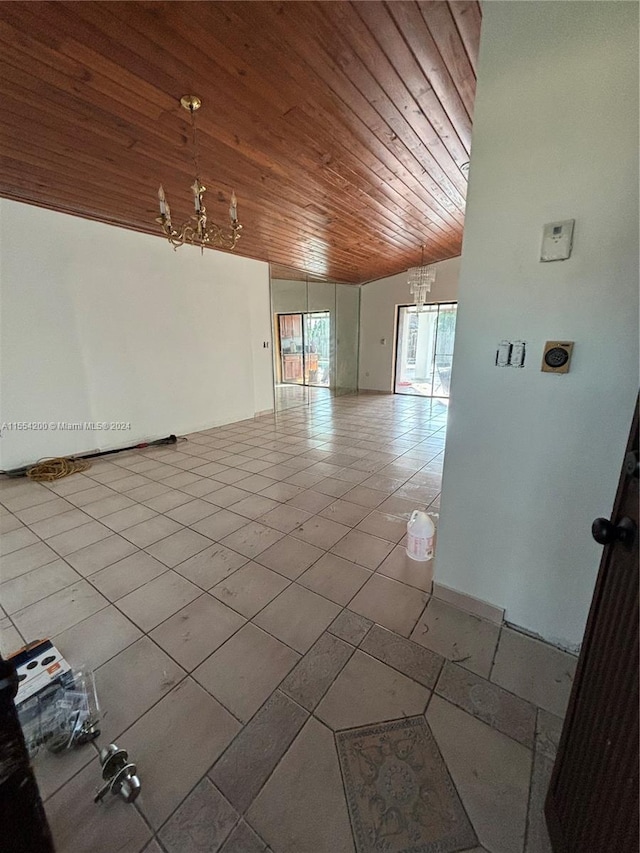 spare room with tile patterned floors, a notable chandelier, and wooden ceiling