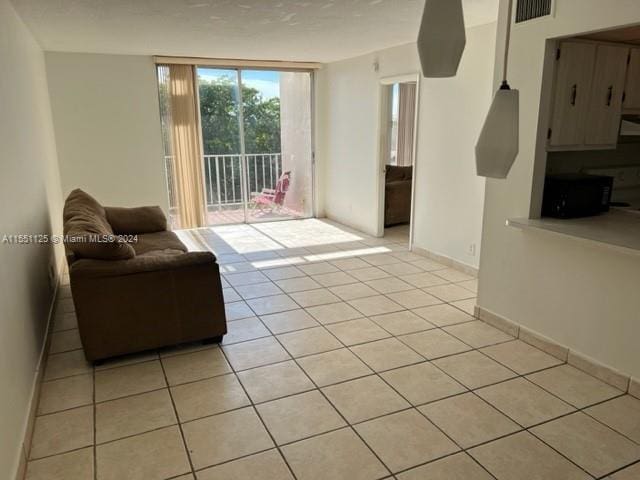 living room featuring expansive windows and light tile flooring