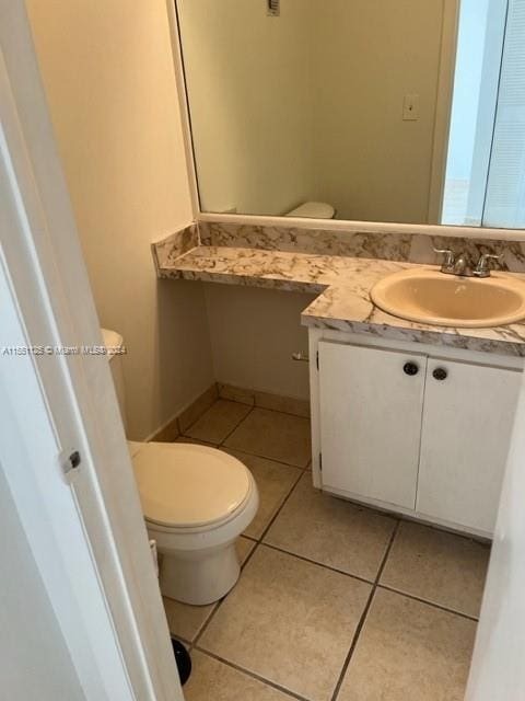 bathroom featuring vanity, tile floors, and toilet