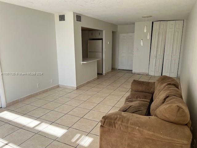 unfurnished living room featuring light tile floors