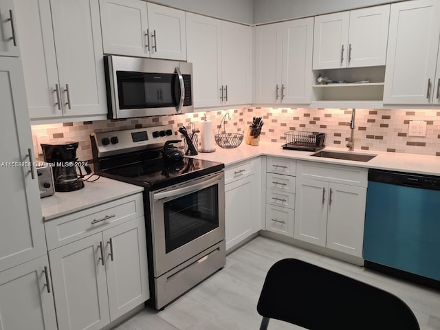 kitchen featuring white cabinetry, tasteful backsplash, appliances with stainless steel finishes, and sink