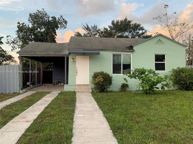 view of front of home with a yard and a carport