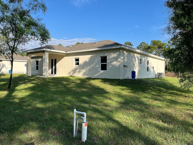 view of side of home featuring a yard and central AC unit