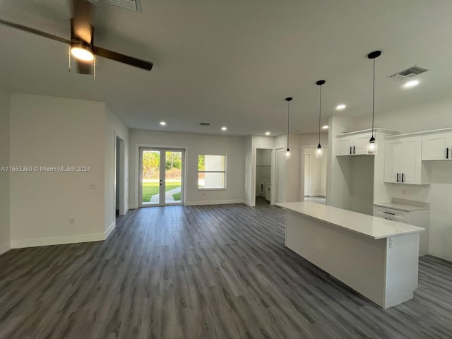 kitchen with ceiling fan, dark hardwood / wood-style flooring, white cabinets, decorative light fixtures, and a center island