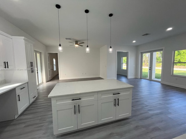 kitchen with white cabinetry, pendant lighting, and hardwood / wood-style flooring