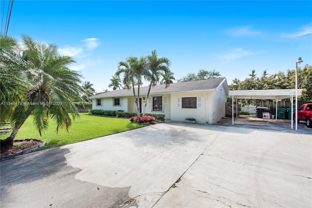 view of front of property with a front yard and a carport