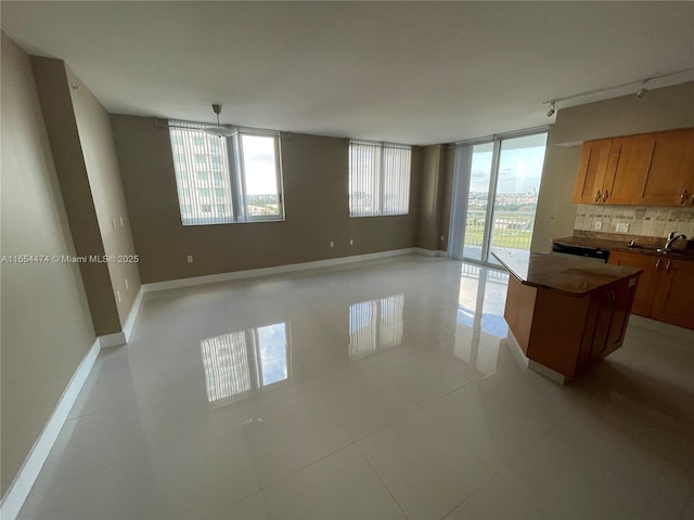 kitchen featuring backsplash, a center island, light tile patterned floors, and plenty of natural light