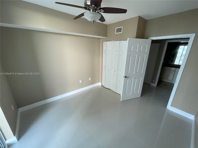 unfurnished bedroom with tile patterned floors, ceiling fan, and a closet