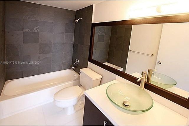 full bathroom featuring toilet, tiled shower / bath combo, and oversized vanity