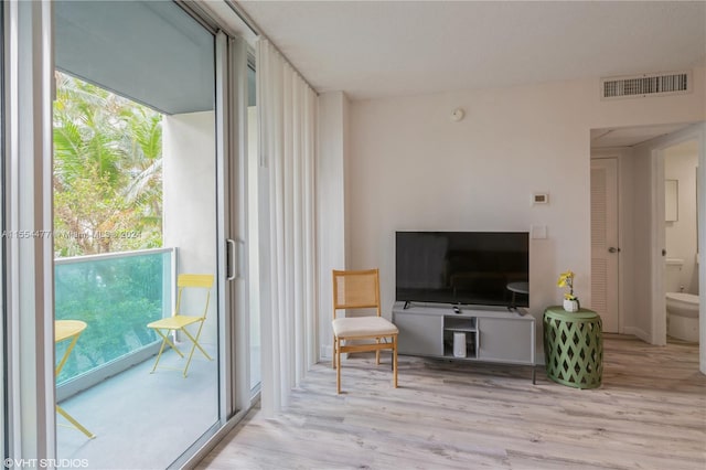 living room featuring a healthy amount of sunlight and light hardwood / wood-style floors