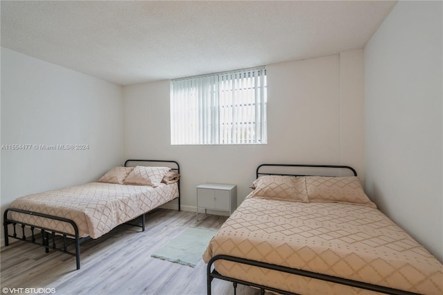 bedroom featuring a textured ceiling and light wood-type flooring