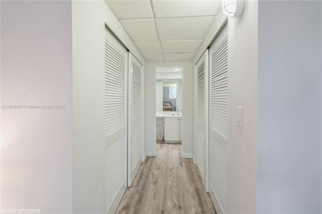 corridor featuring a drop ceiling and light wood-type flooring