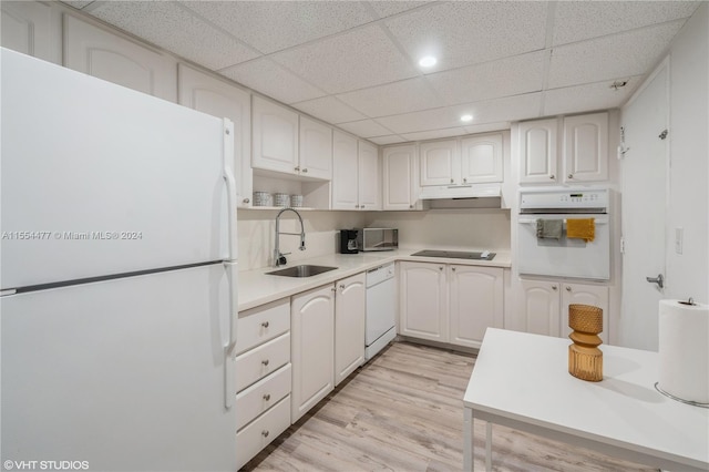 kitchen featuring white appliances, sink, white cabinets, and light wood-type flooring