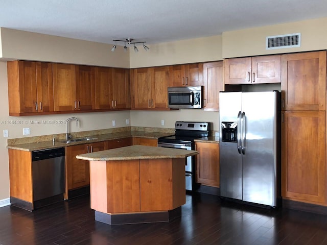 kitchen with dark hardwood / wood-style flooring, a center island, stainless steel appliances, and sink