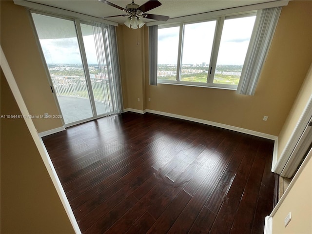 unfurnished room with ceiling fan and dark wood-type flooring