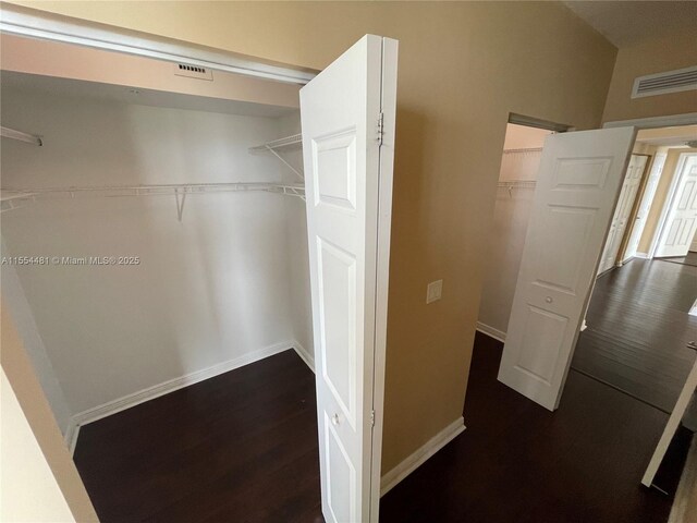 spacious closet featuring dark hardwood / wood-style flooring