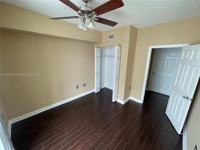 unfurnished bedroom with a closet, ceiling fan, and dark wood-type flooring