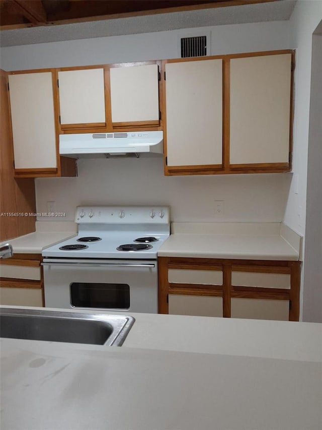 kitchen featuring white cabinets and white electric range