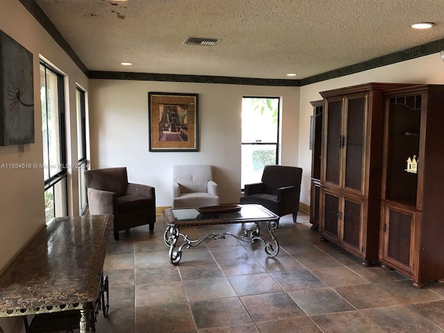 living area with dark tile floors and a textured ceiling