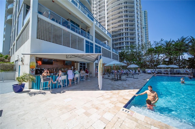 view of swimming pool with a patio area and an outdoor bar