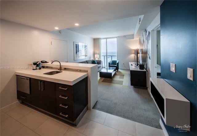 kitchen featuring sink, kitchen peninsula, light tile patterned floors, expansive windows, and dark brown cabinets