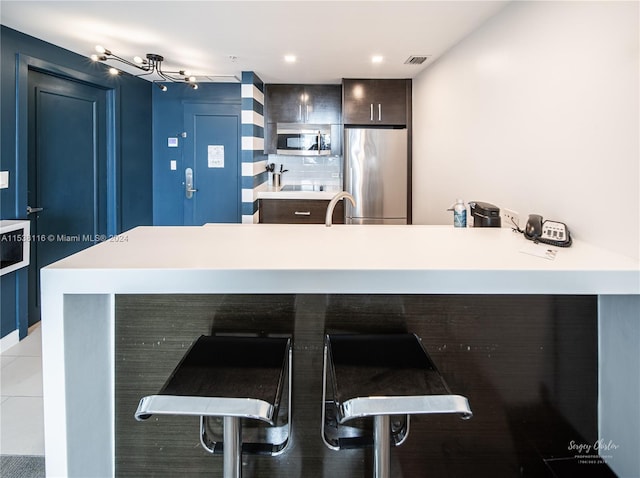 kitchen with sink, kitchen peninsula, a kitchen breakfast bar, and stainless steel appliances