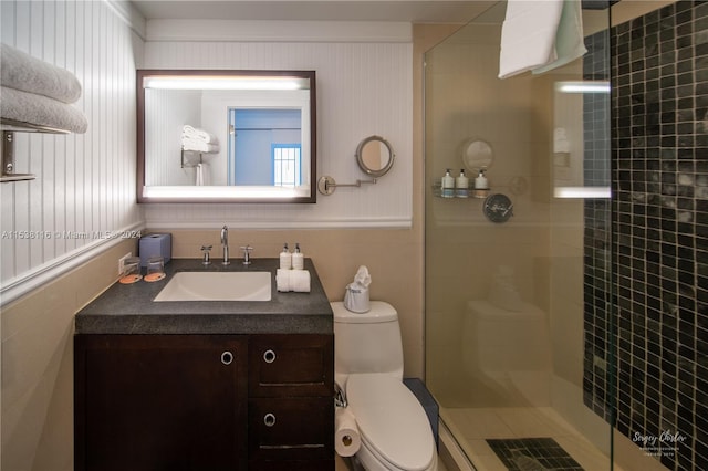 bathroom with a shower with door, toilet, and vanity