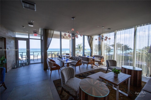 sunroom / solarium with a water view and an inviting chandelier