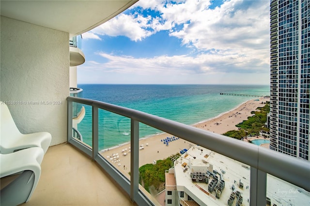 balcony featuring a water view and a beach view