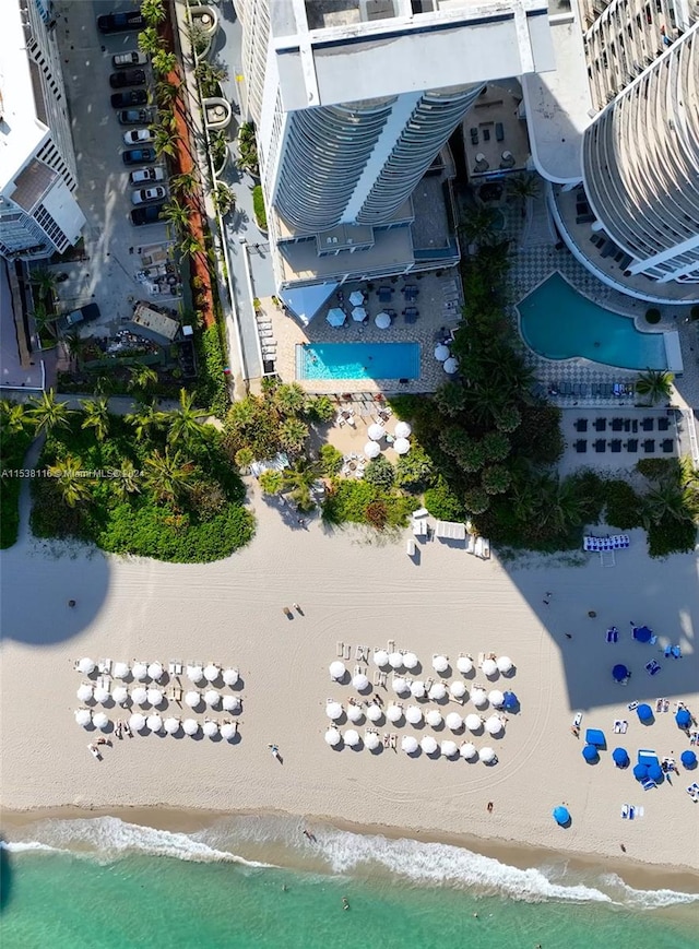 birds eye view of property with a water view and a view of the beach