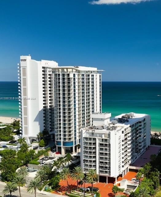 birds eye view of property featuring a water view and a beach view