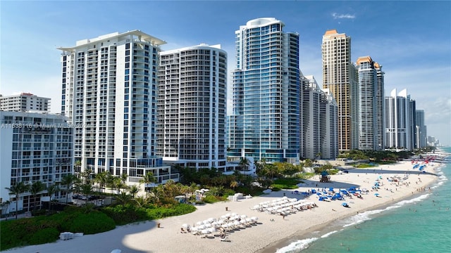 view of property with a water view and a beach view