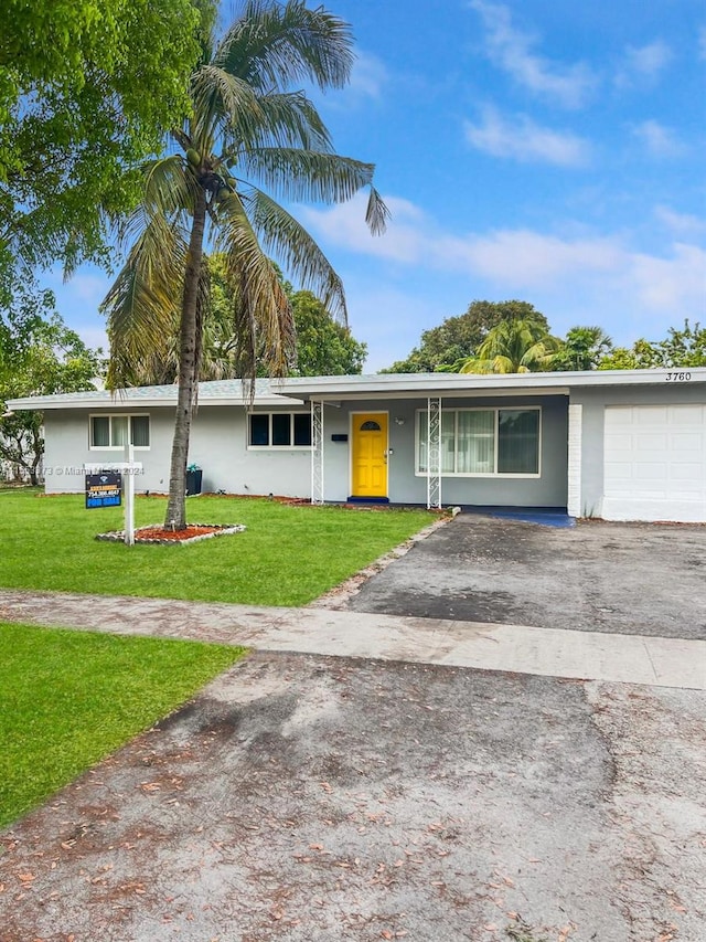 ranch-style home with a front lawn and a garage