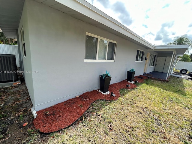 view of property exterior with cooling unit and a yard