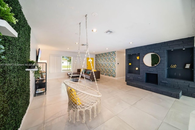 living room featuring exterior fireplace and light tile patterned floors