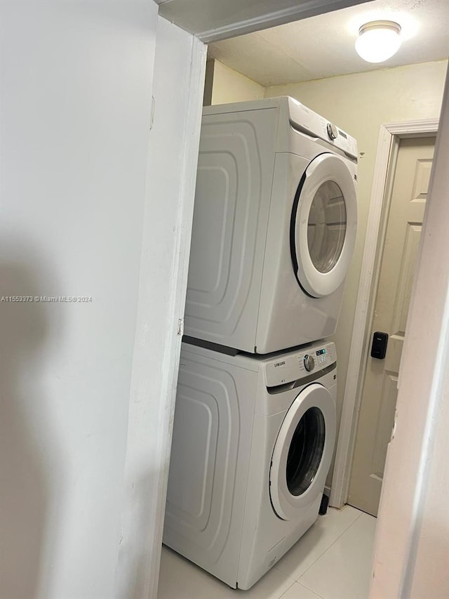 washroom featuring light tile patterned floors and stacked washer and clothes dryer