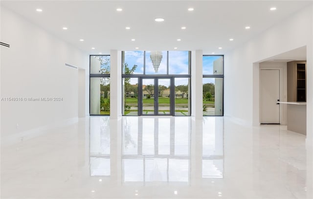 unfurnished room featuring floor to ceiling windows and light tile floors