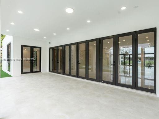 unfurnished room featuring french doors and a healthy amount of sunlight