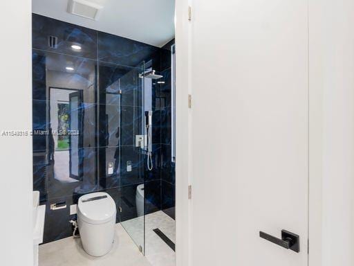 bathroom featuring toilet, tile flooring, and an enclosed shower